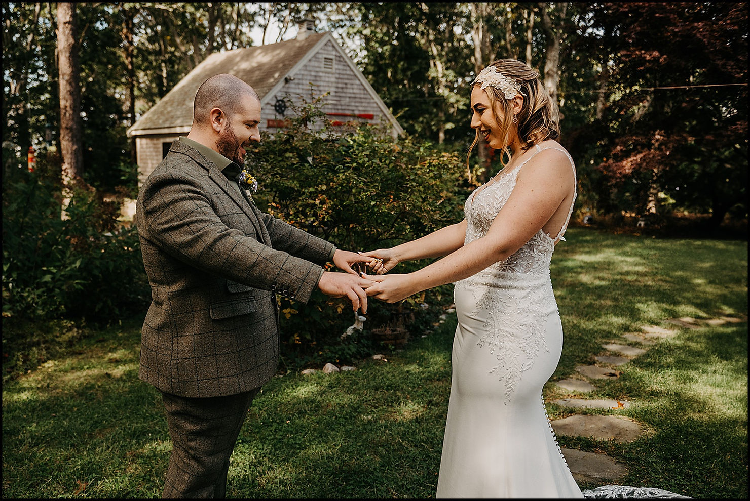 A bride and groom smile and hold hands during their first look at their Chequessett Club wedding.