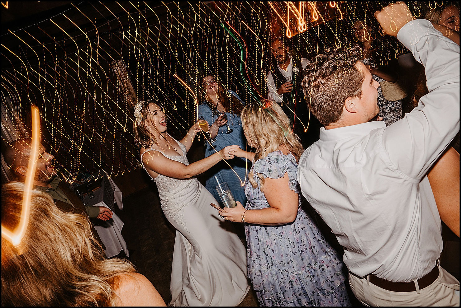A bride dances hand in hand with a wedding guest.