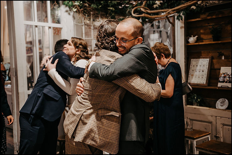 A bride and groom hug guests as they arrive for a New York City wedding reception.