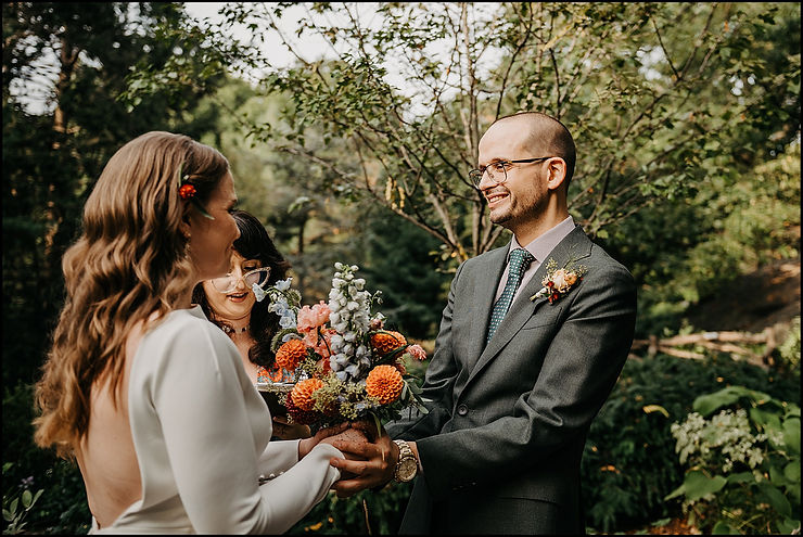 A bride and groom hold hands during their Shakespeare Garden wedding ceremony.