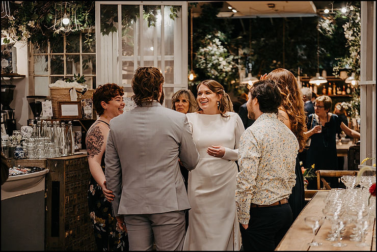 A bride laughs with guests beside a bar at Maman Tribeca.
